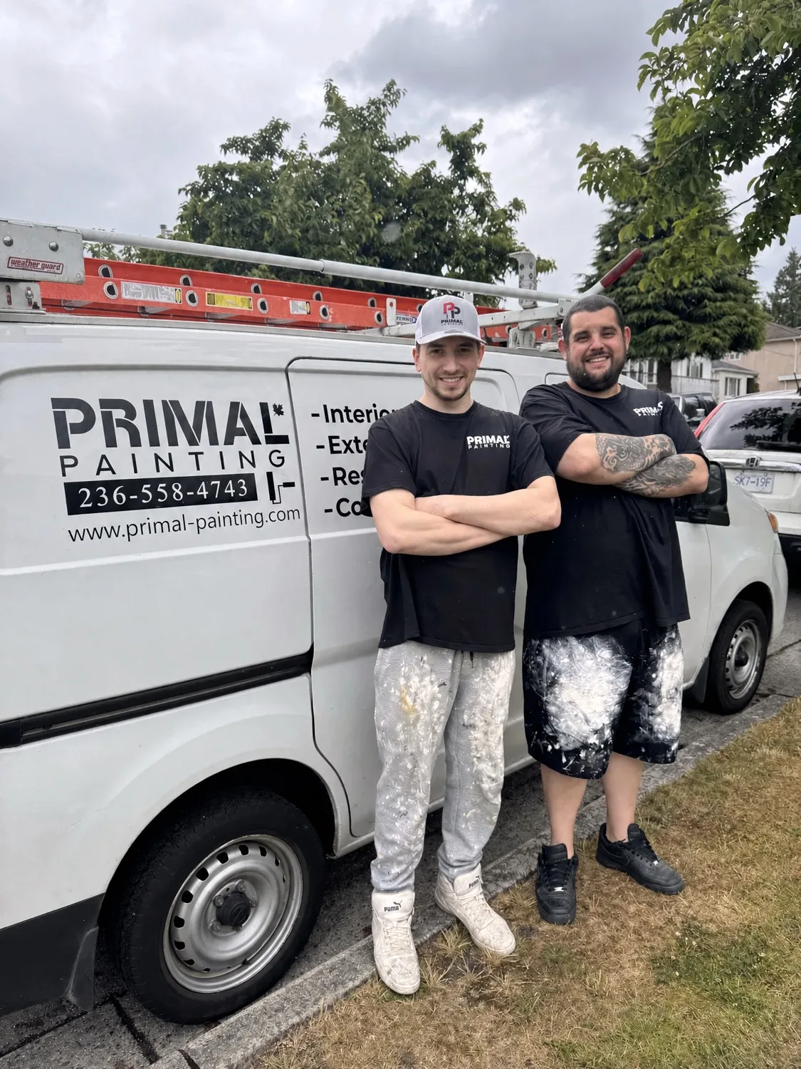 Primal Painting owners Steve and Josh smiling in front of the company van